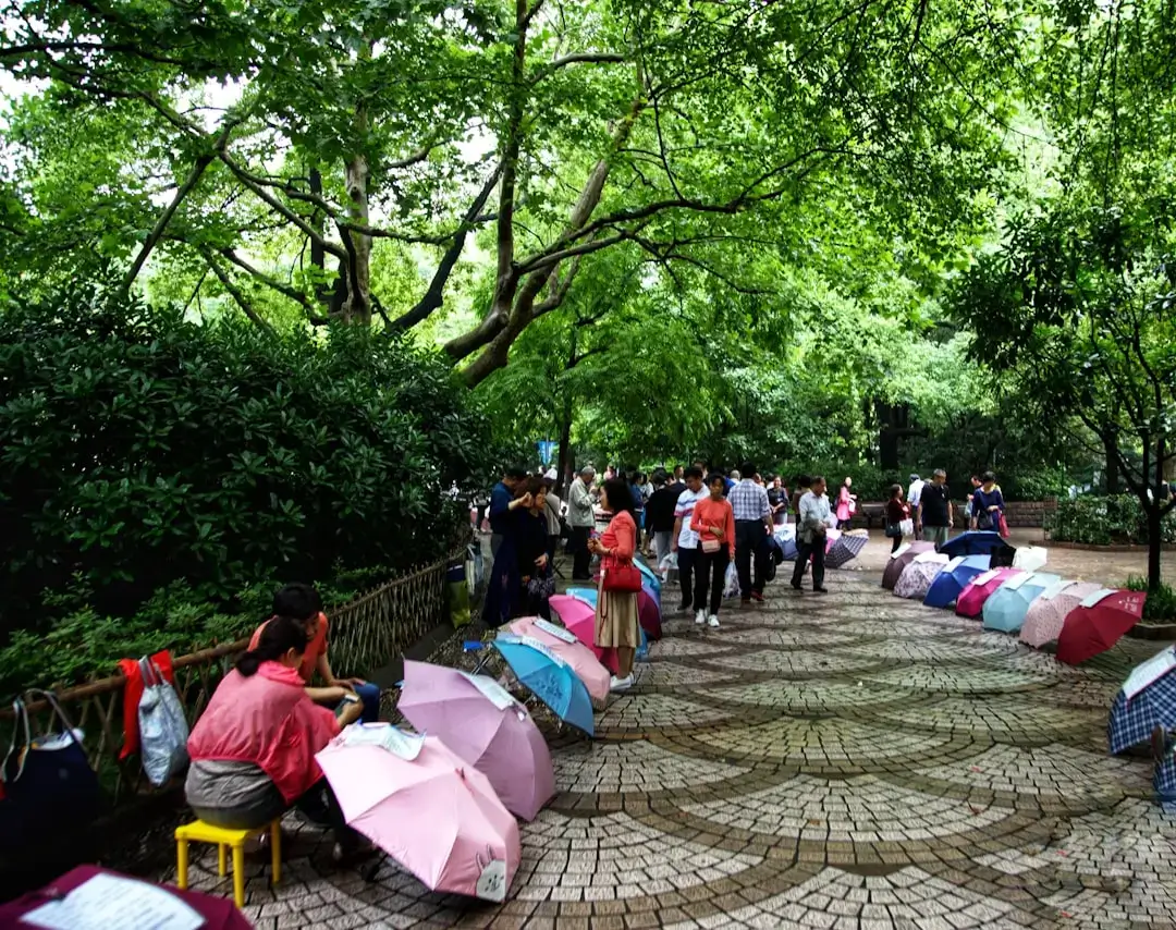 Uczestnicy warsztatów siedzący na ławkach pod drzewami w relaksującej atmosferze