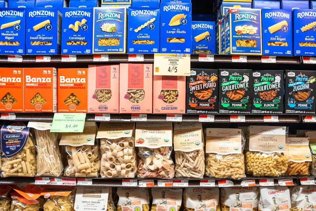 Row of colorful beverage cartons and juice boxes neatly organized on a retail store shelf.