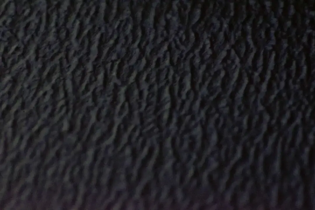 Close-up of a dark and grainy black chimney soot texture with organic charcoal details.