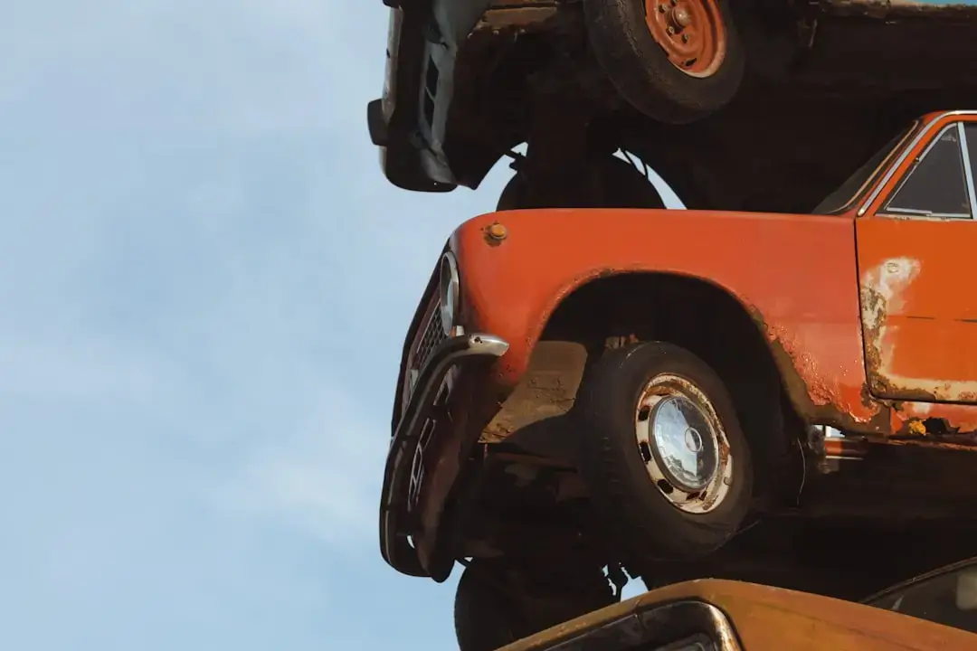 A large-scale recycling facility featuring organized stacks of metal car parts and scrap vehicles for sustainable materials recovery.