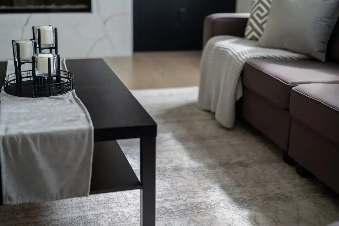 A comfortable modern living room featuring a plush sofa, neutral color palette, and warm ambient lighting.