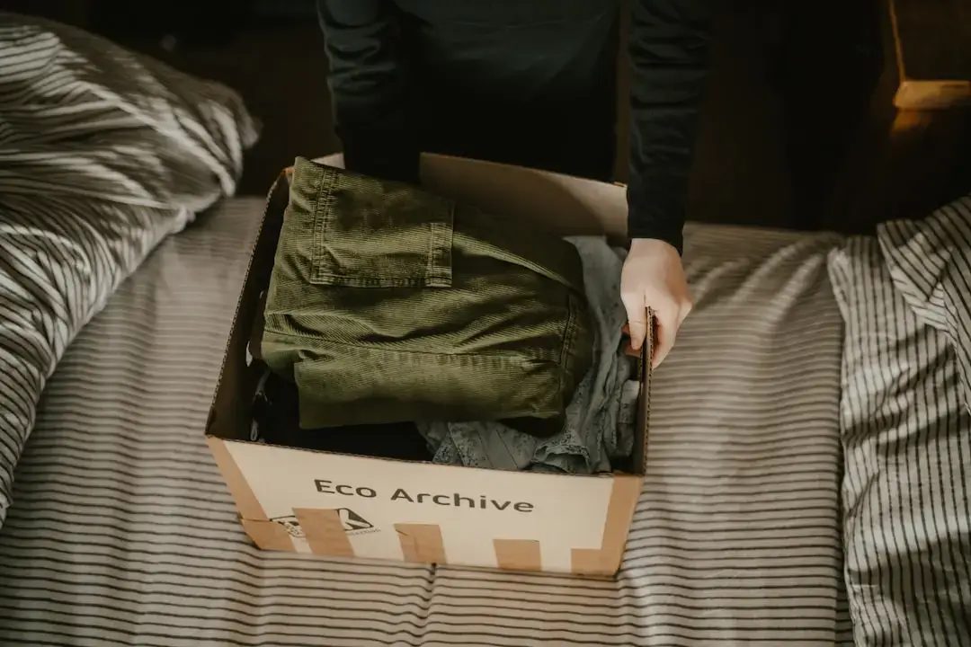 A sustainable cardboard box surrounded by green leaves representing eco-friendly packaging solutions.