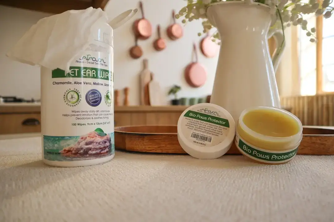A collection of natural cleaning supplies including glass bottles, wooden brushes, and fresh lemons on a bright surface.