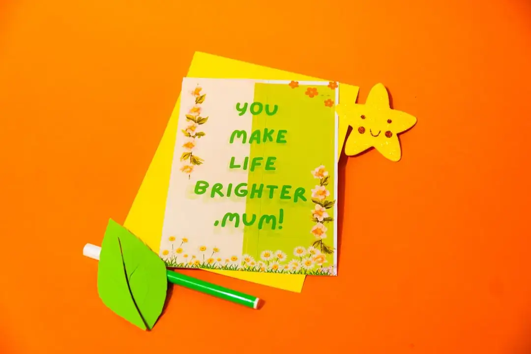 A happy family sitting together at a wooden table creating colorful handmade paper decorations.