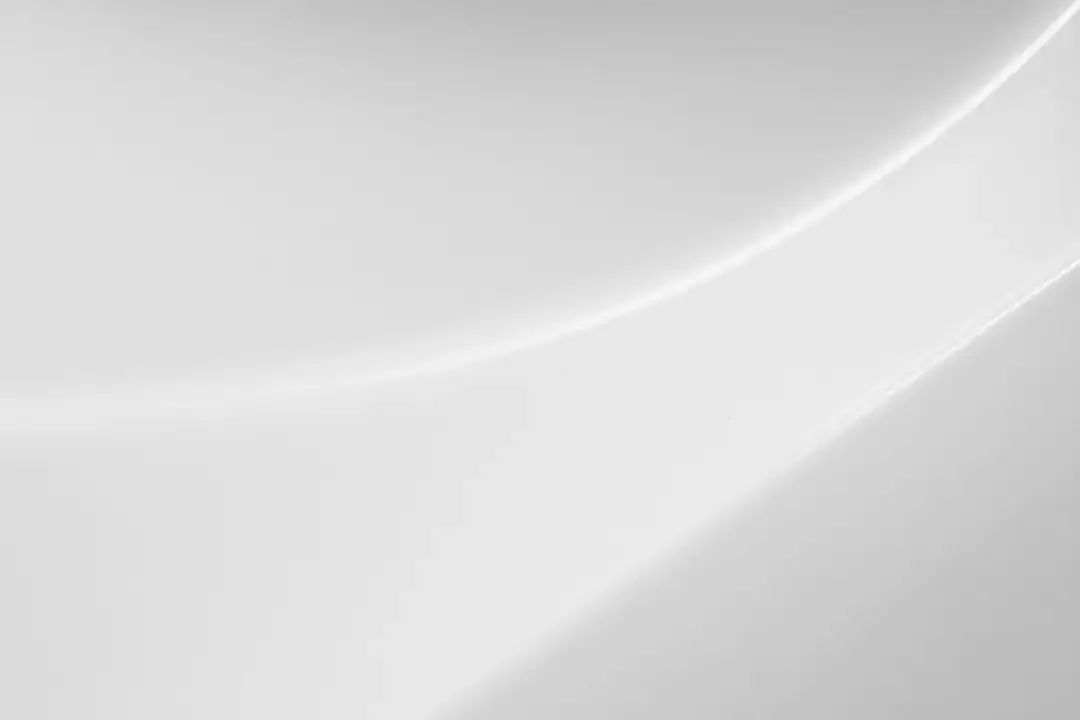 Close-up view of a clean glossy white paper packaging texture with subtle light reflections.