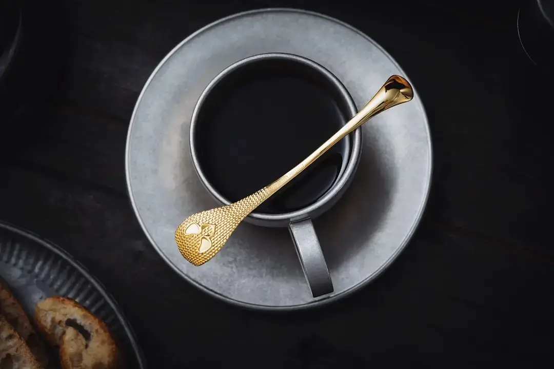 Nahaufnahme von dickflüssigem goldenem Honig, der langsam von einem hölzernen Honiglöffel tropft