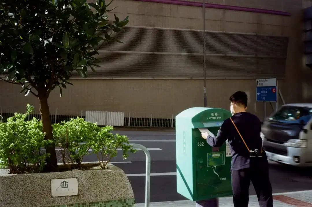 A large green metal textile recycling bin for collecting used clothing outdoors.
