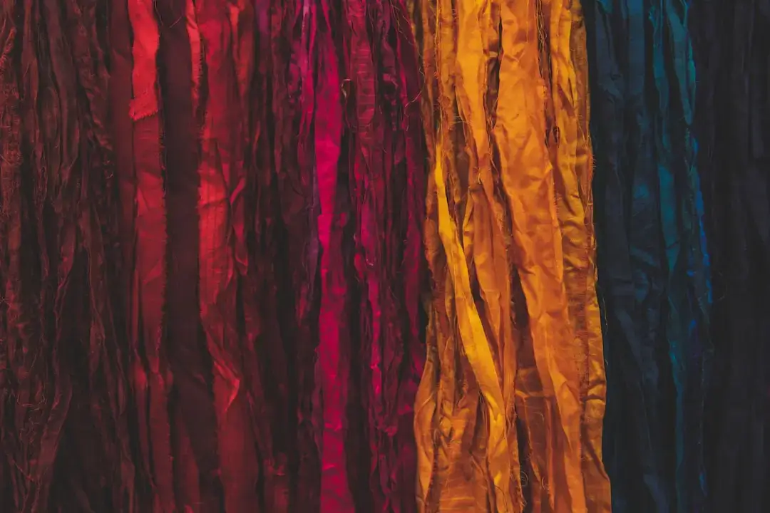 Close-up of colorful DIY bracelets made from braided recycled fabric scraps on a person's wrist