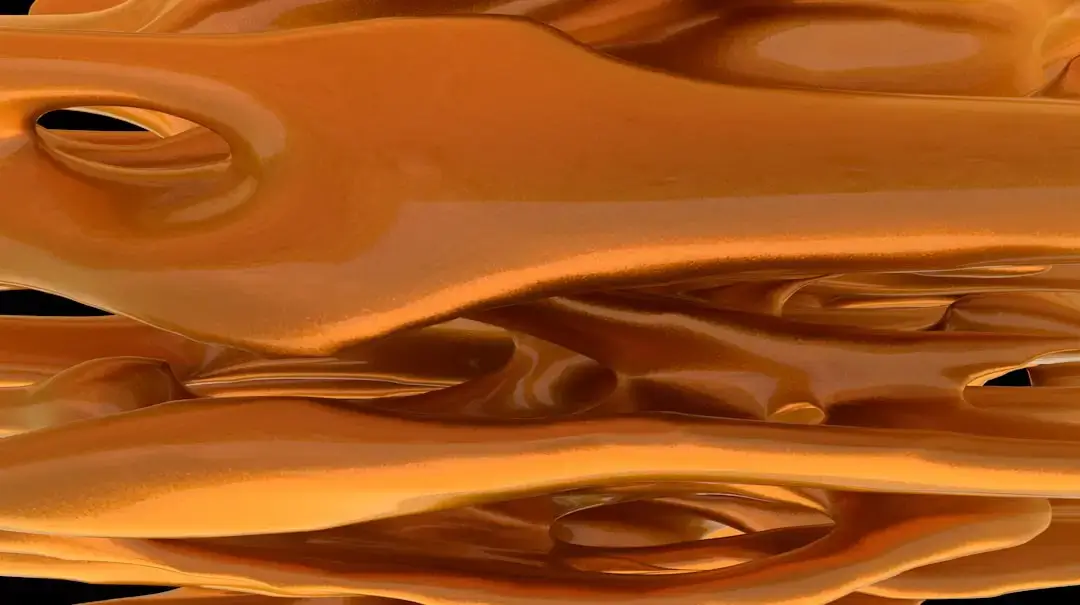 Close-up of golden honey flowing smoothly during a quality control test.