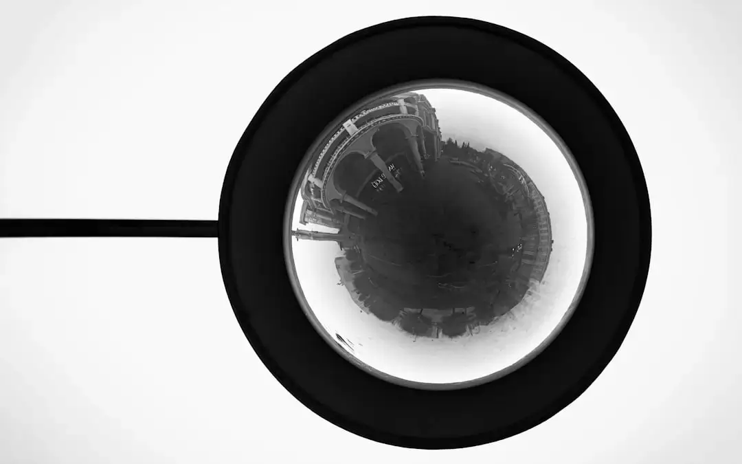 Close-up of a large industrial parabolic mirror used for detection and light reflection in a factory setting.