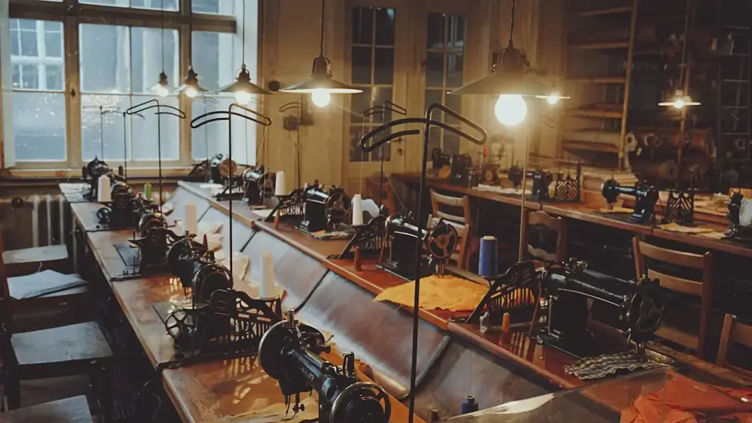 Row of professional industrial sewing machines in a bright textile manufacturing factory