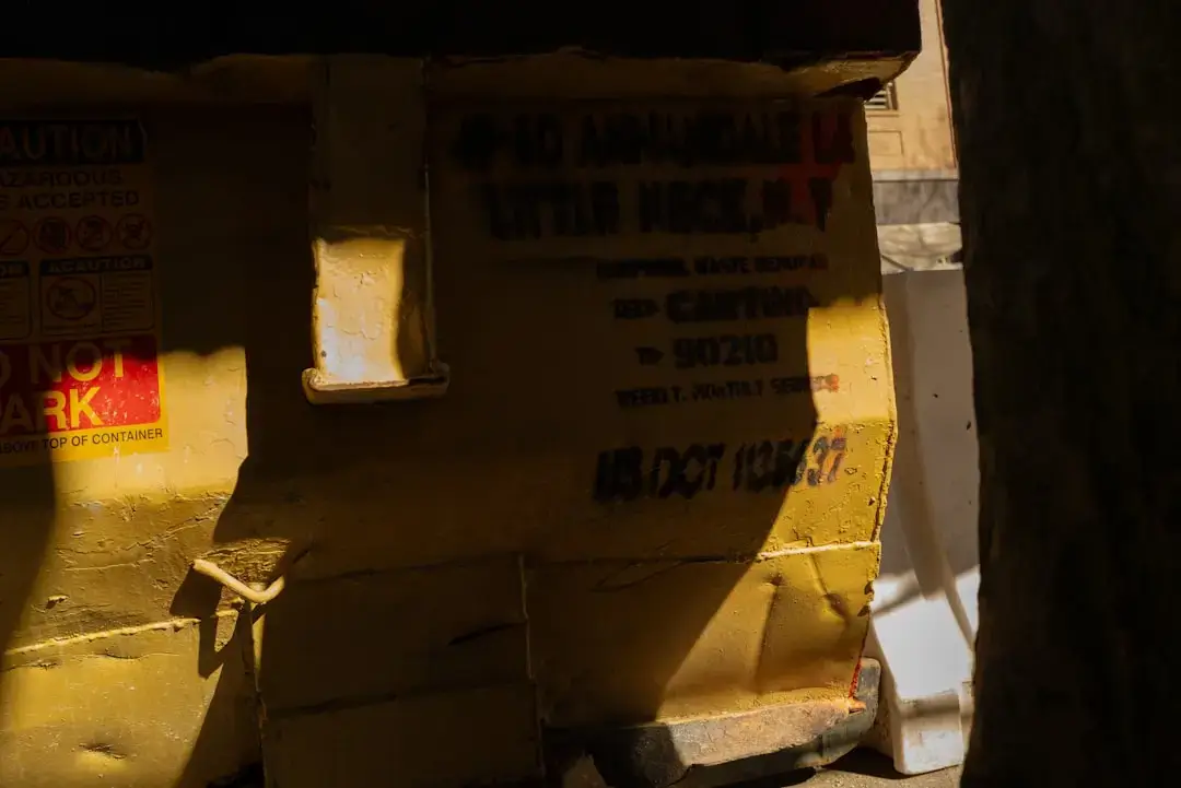 A large yellow industrial waste container placed on a professional construction site for debris management.