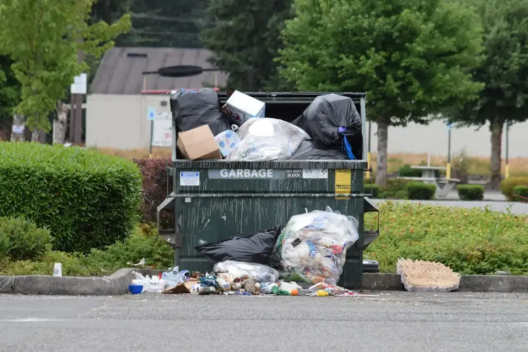 A man carefully sorting domestic waste into different recycling bins at home to promote sustainability.