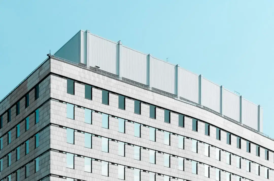 Close-up of white rigid styrofoam insulation boards being installed on a modern building facade for energy efficiency.