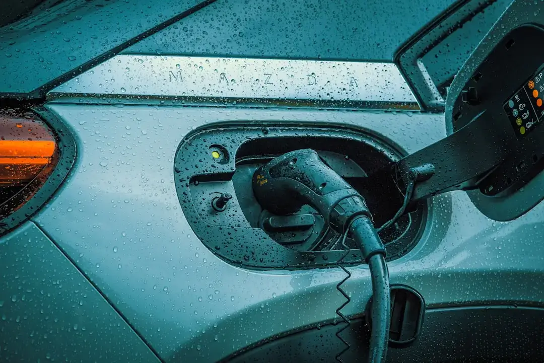 A modern electric vehicle plugged into a fast-charging station at a contemporary urban location.