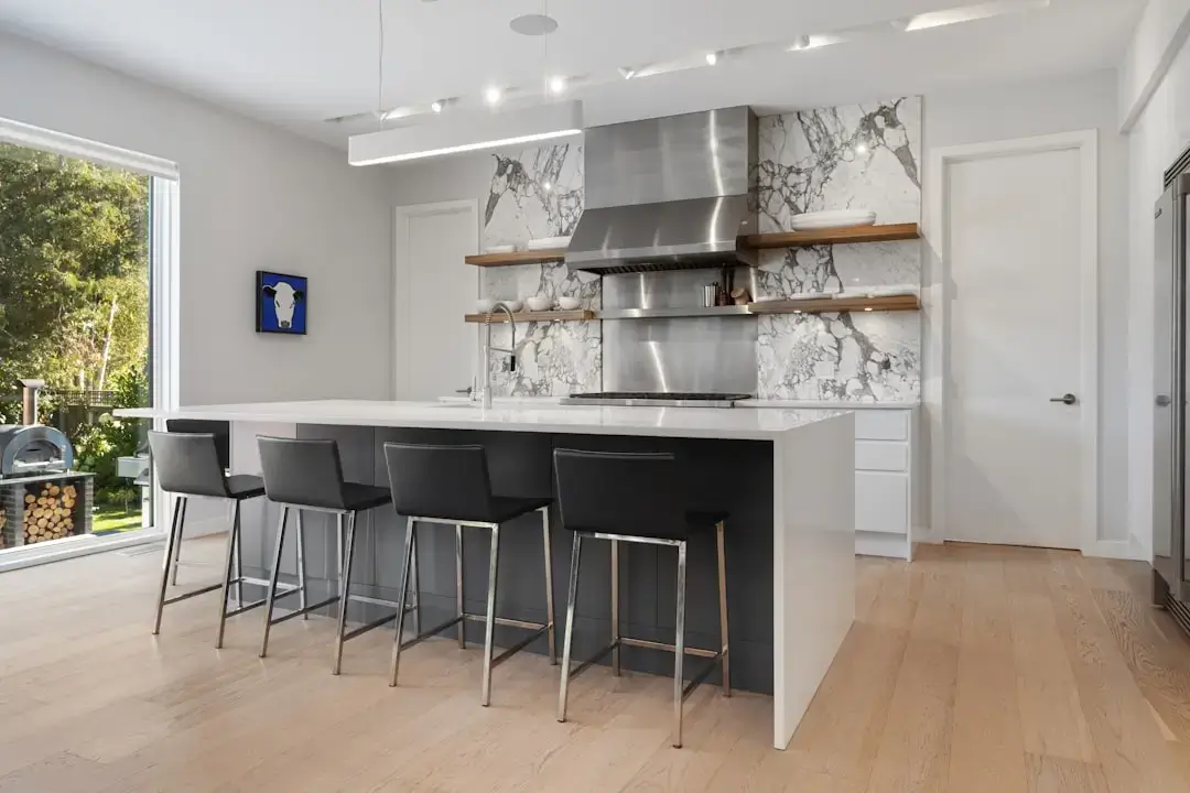 A modern retail showroom featuring rows of new stainless steel kitchen appliances for sale.