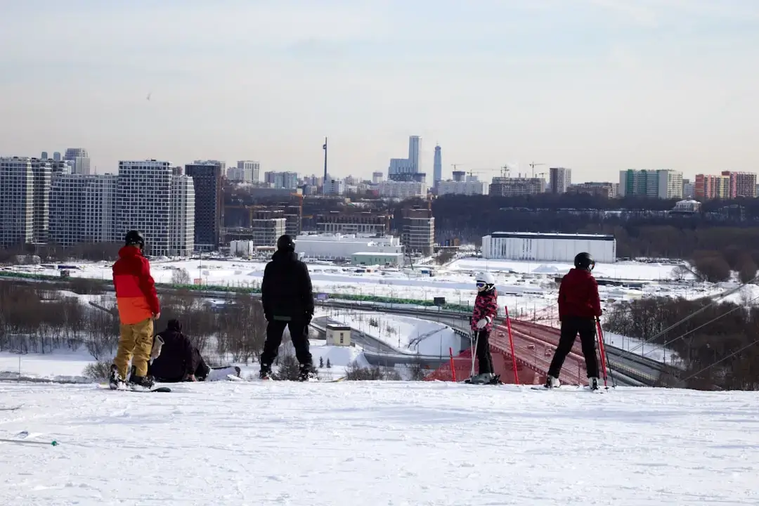 An innovative modern building featuring an active rooftop ski slope with skiers under a blue sky
