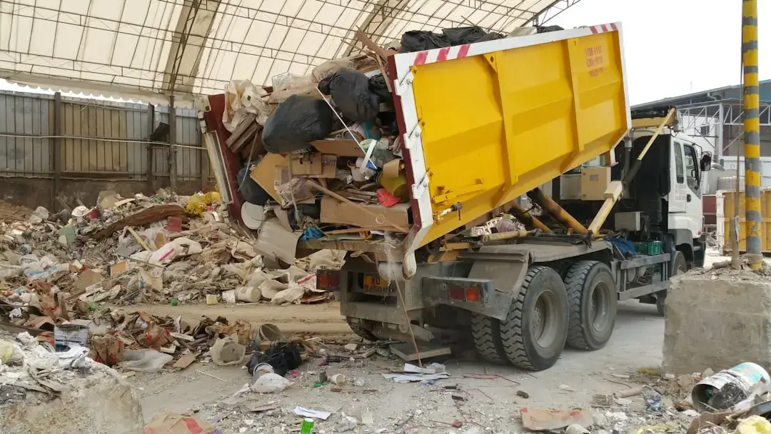 A clean and organized public waste collection point with large containers for segregated recycling and hazardous materials.