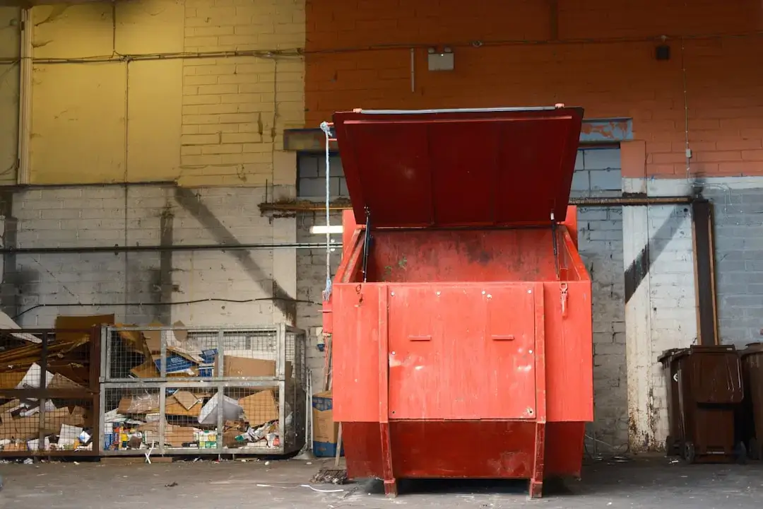 An automated industrial waste sorting conveyor belt system inside a large-scale recycling facility processing plastic and paper.