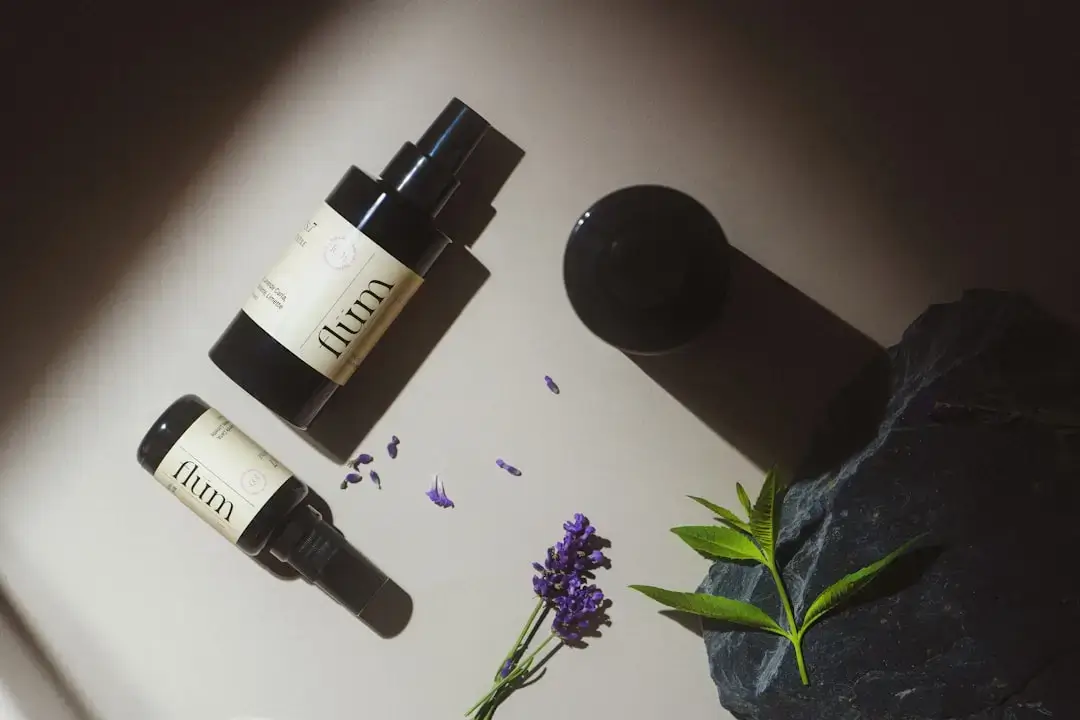 An aesthetic overhead view of organic skincare products, dried flowers, and wooden accessories on a neutral background.