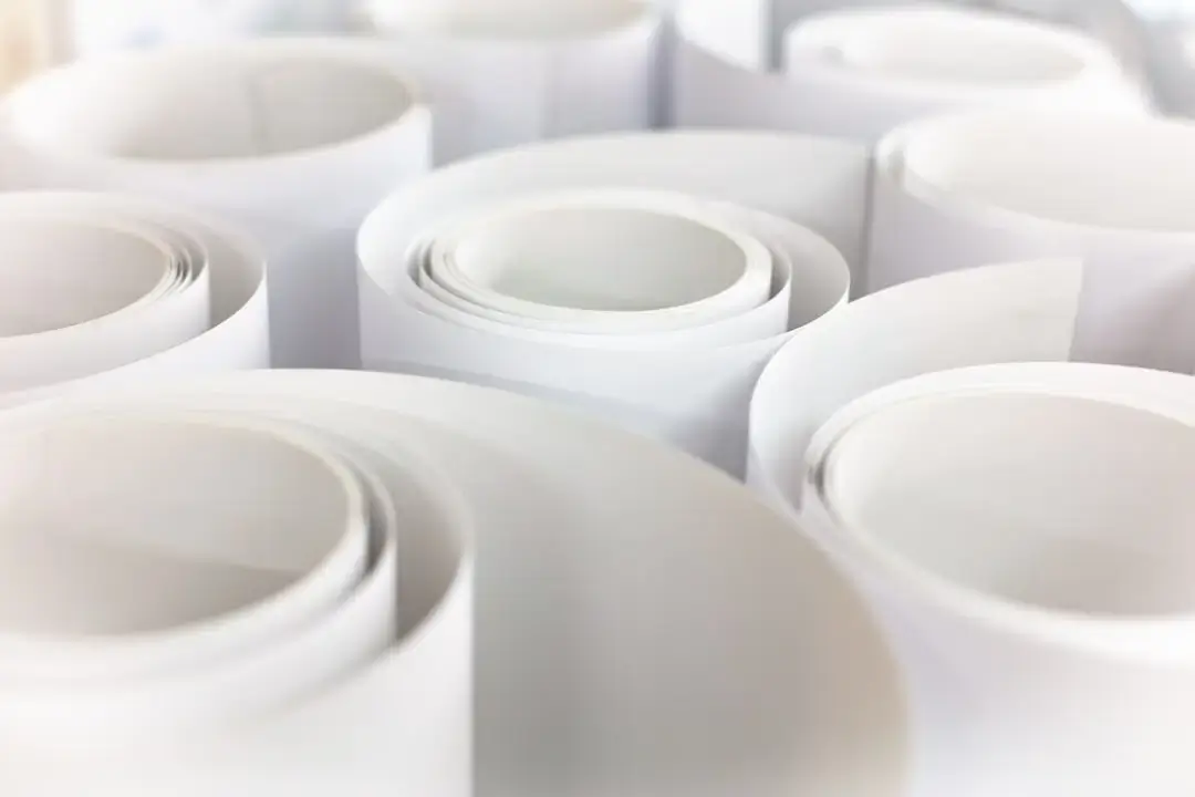 A macro top-down view of multiple white thermal paper shopping receipts stacked together.