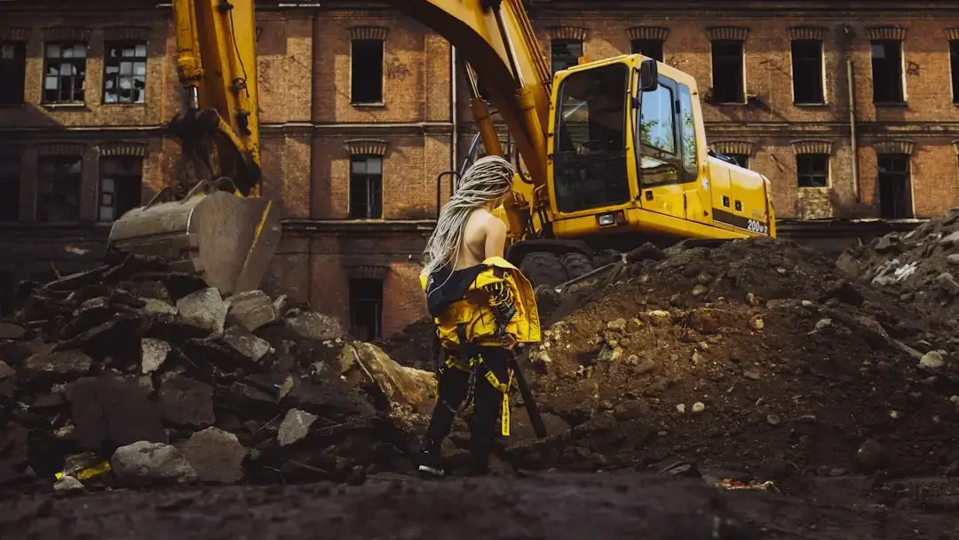 A pile of discarded yellow polyurethane foam insulation sheets and construction waste at a demolition site.