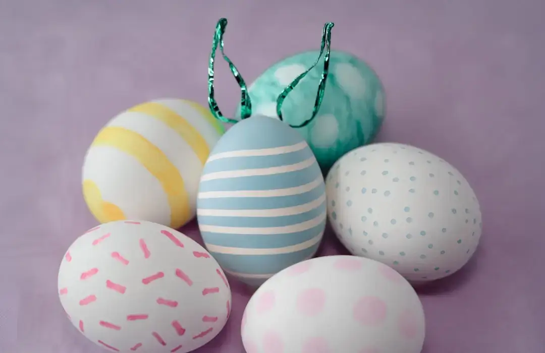 A group of colorful handmade Easter crafts made from recycled materials on a wooden table.