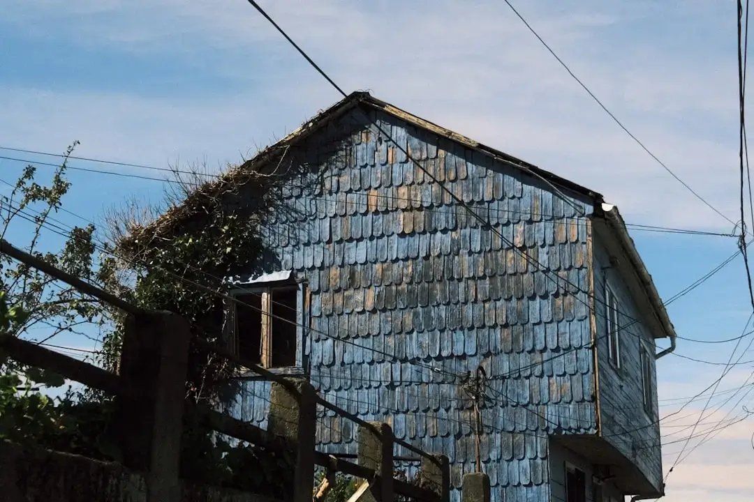 Close-up view of weathered grey and brown wooden shingles on a rustic building roof.