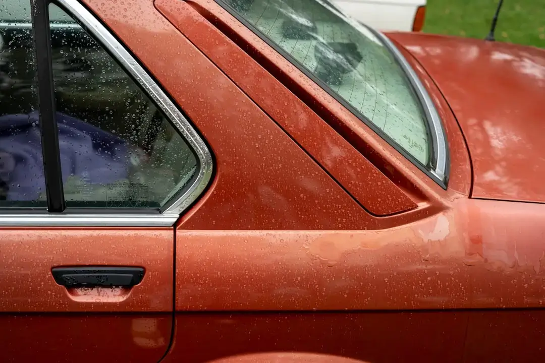 Close-up of a shattered side window of a car showing cracked safety glass fragments.