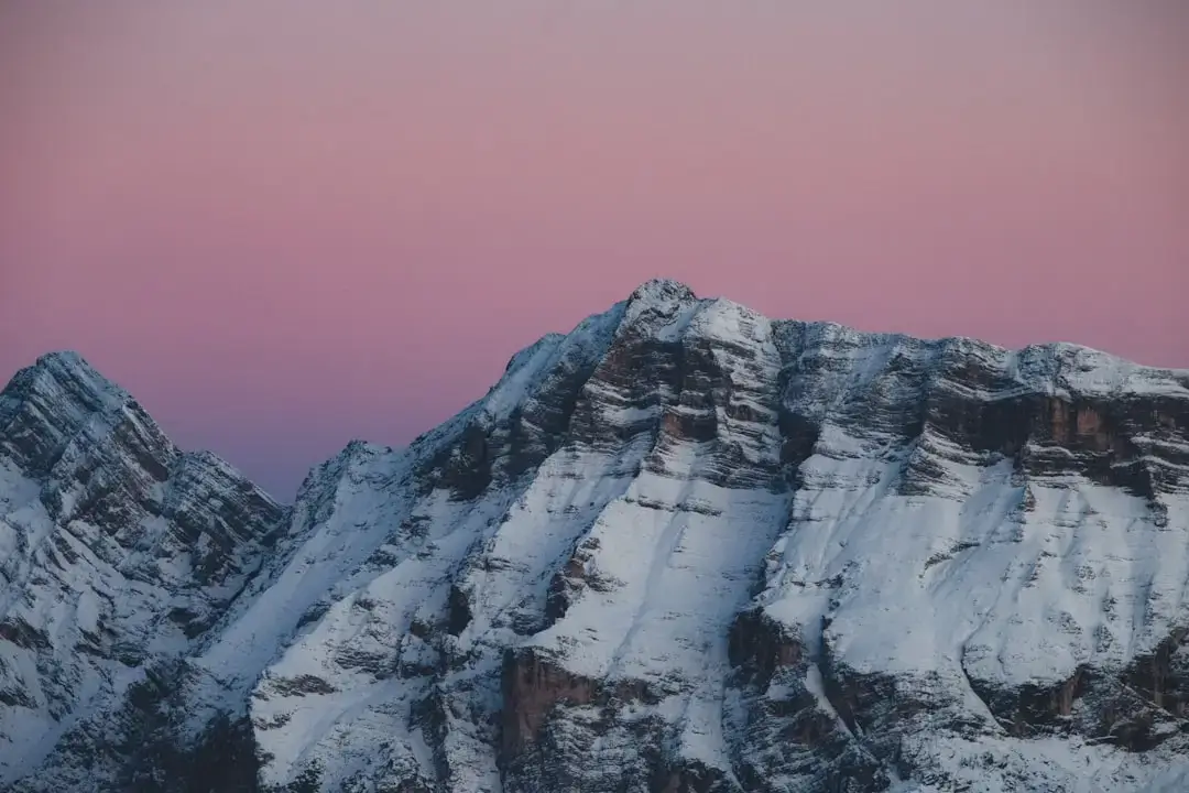 Snow-covered mountains under a pink sky