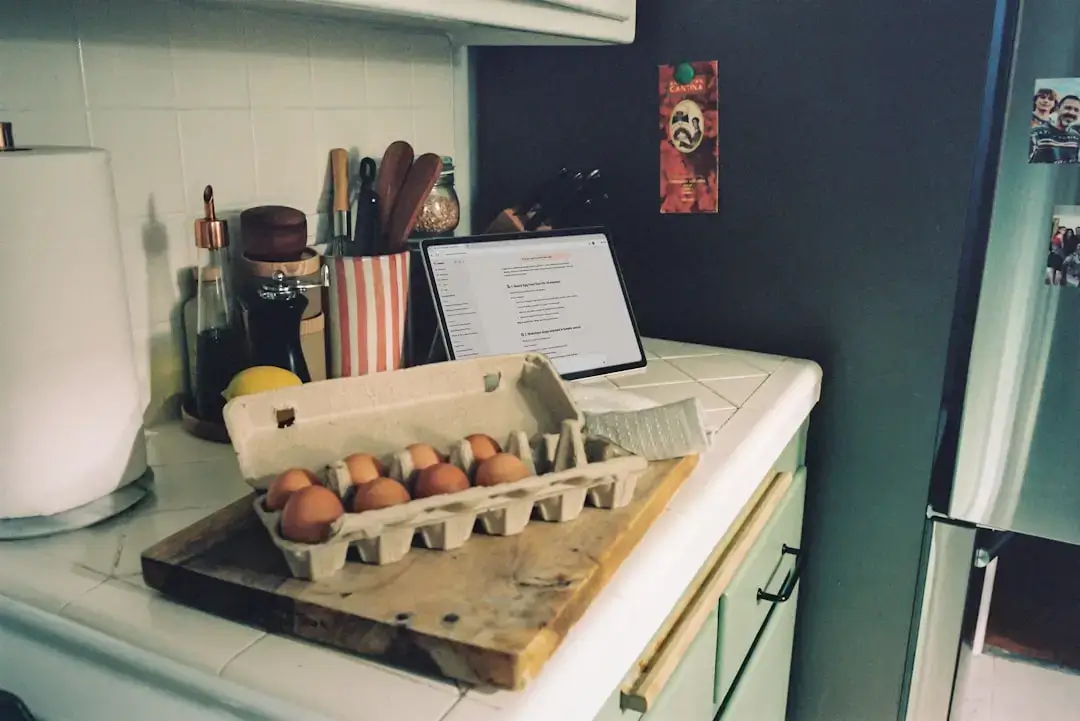 Una persona colocando cáscaras de verduras orgánicas y restos de comida en un elegante cubo de compostaje interior sobre una encimera de cocina luminosa.