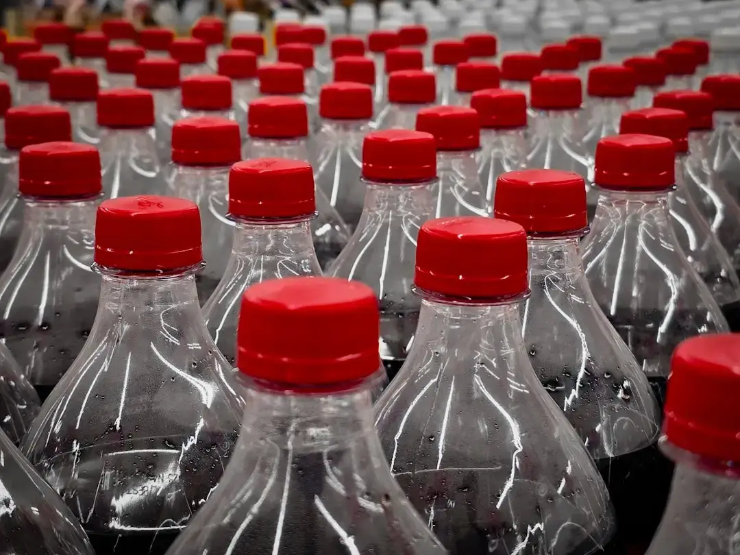 A close-up shot of hands sorting plastic bottles into a designated recycling bin