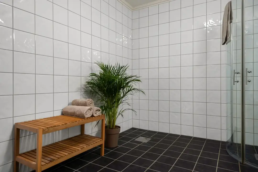 A modern water-saving showerhead spraying a gentle mist of water in a contemporary bathroom to illustrate eco-friendly water conservation.
