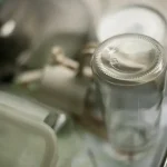 Close-up of an empty glass bottle on a shelf.