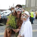 Two people in owl masks and costumes