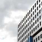 a tall building with many windows and a sky background