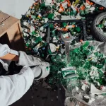 person in white long sleeve shirt holding green and black plastic toy