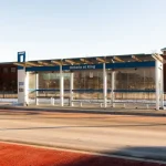 A modern bus shelter on a sunny day.
