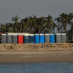 A row of beach huts sitting on top of a sandy beach
