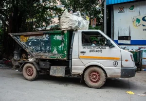 A white garbage truck filled with trash.