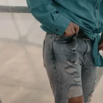 a woman wearing a blue shirt and ripped jeans