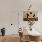 Modern dining room with desert-themed wall hanging.