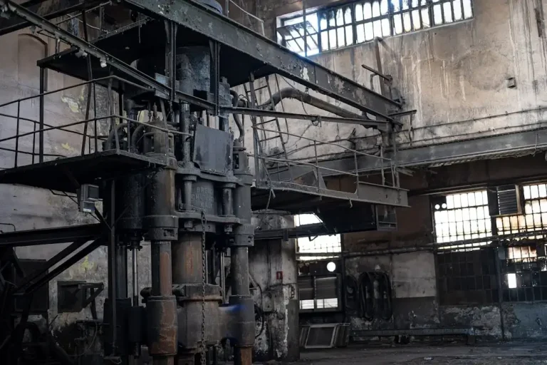 Old machinery sits in a derelict industrial building.