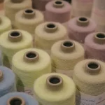 Spools of colorful yarn arranged closely together