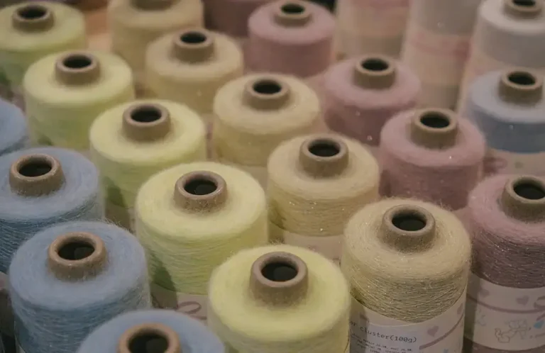 Spools of colorful yarn arranged closely together