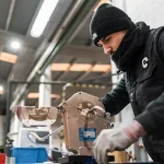 A man is working on machinery in a workshop.