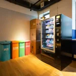 black and blue vending machine beside brown wooden cabinet