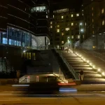 City street with illuminated stairs and blurred car