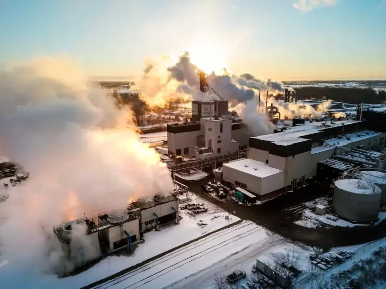 Industrial factory emitting steam on a snowy day