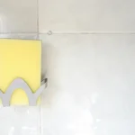 yellow and black paper on white ceramic tile